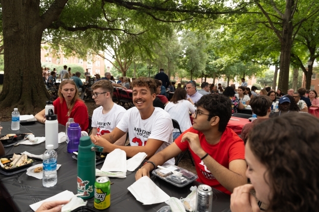 Seated students smiling at the orientation picnic