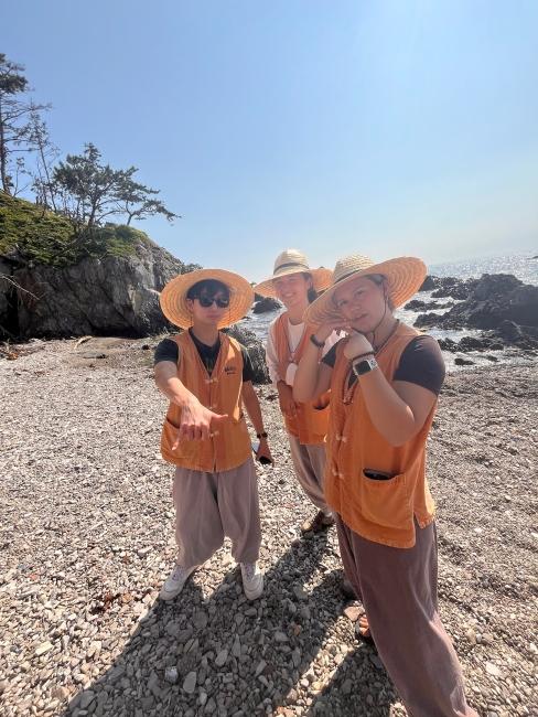 a group of students smiling together wearing straw hats