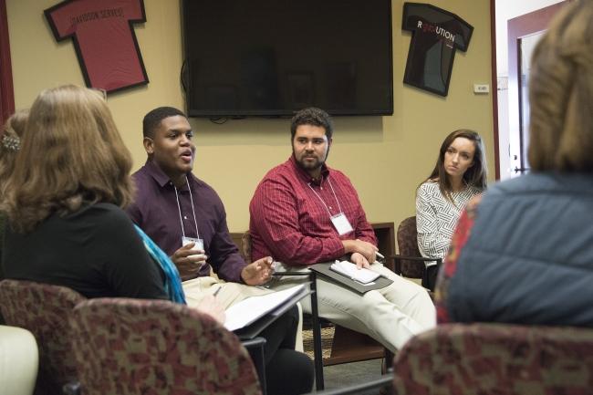 a group of students sit around discussing in chairs