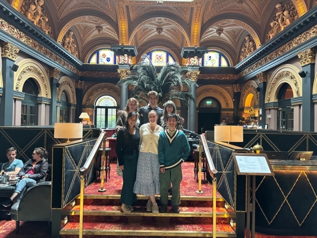 a group of students pose together in a fancy tea parlor