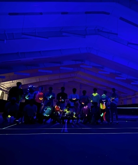 a group of people playing glow-in-the-dark tennis