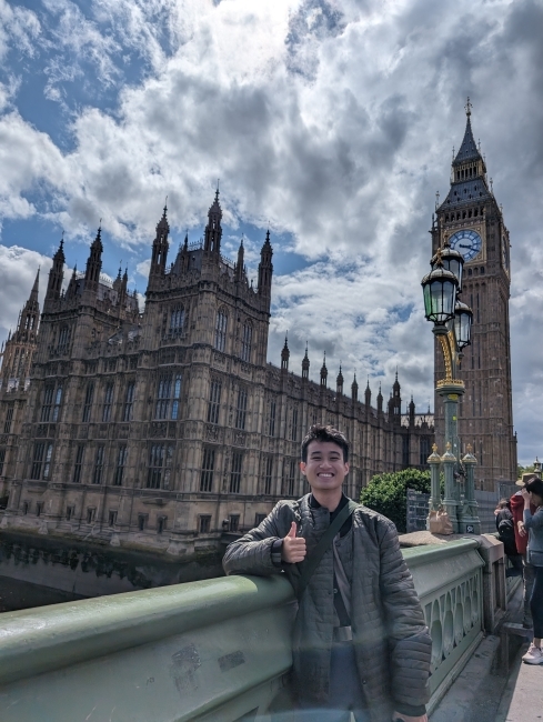 a young Vietnamese man stands in front of Big Ben in London