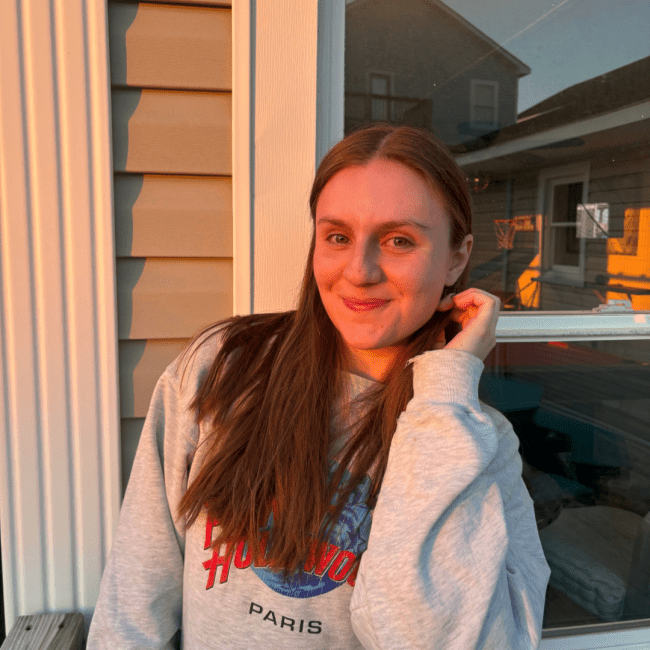 a young white woman smiling at sunset