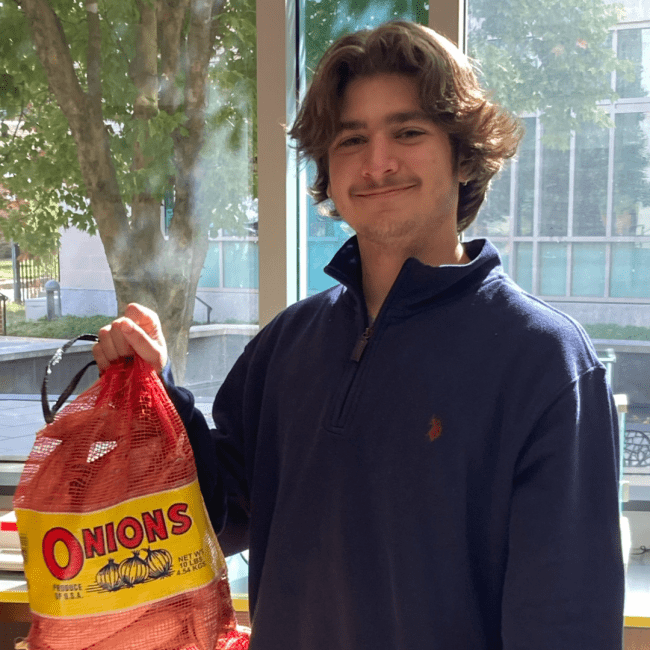 a young man holding a bag of corn and smiling