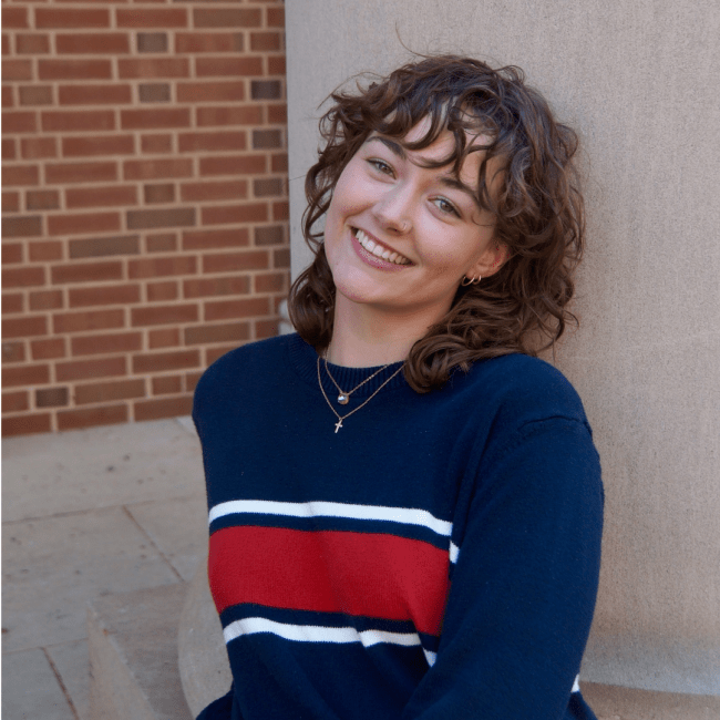 a young white woman wearing a sweater and smiling