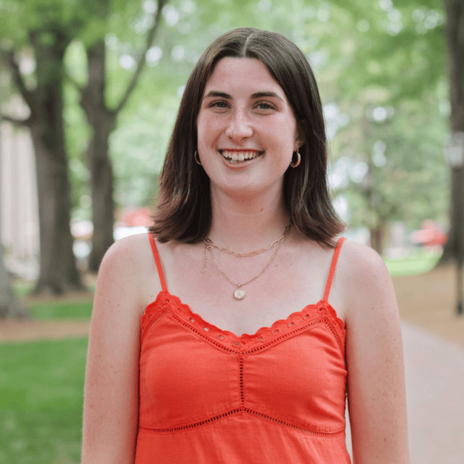 a young white woman smiling on a college campus