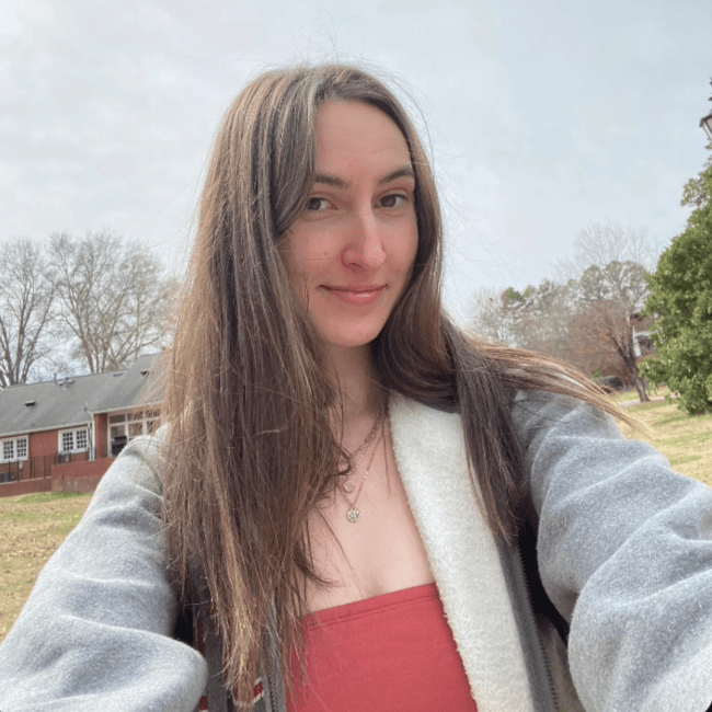 a young white woman smiling wearing a sweatshirt