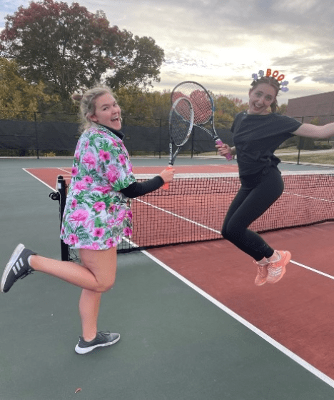 a group of young women jumping in halloween costumes while playing tennis