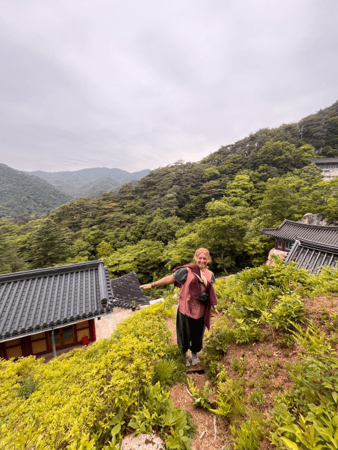 a young woman standing on a mountain