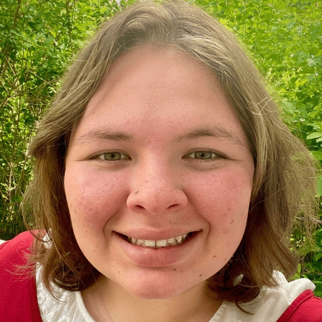 a young woman smiling and wearing a red top