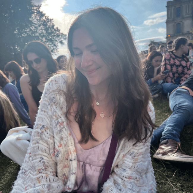 a young white woman smiling at a table outside