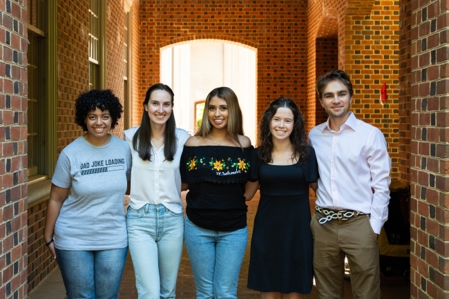 a group of young people standing together in a brick hallway