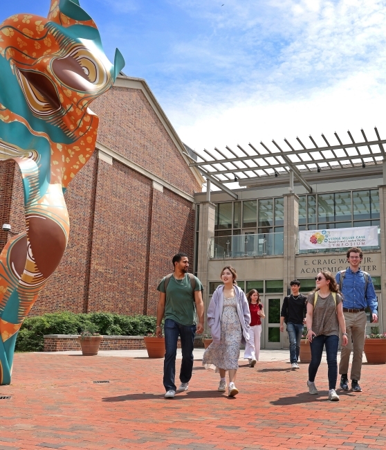 a group of students walk in front of an academic building