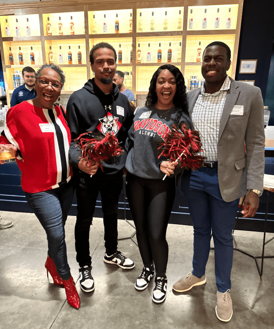 Four Davidson alums wearing red at happy hour event