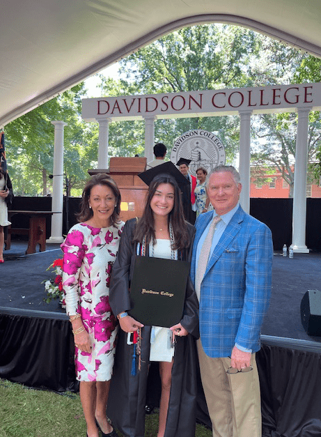 parents with their daughter at her graduation in regalia