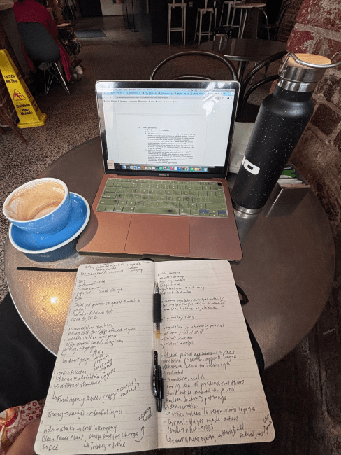 a young woman's laptop, notebook and coffee cup