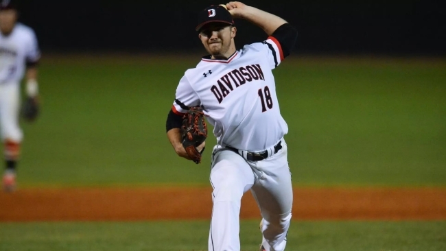 a young man wearing a Davidson College baseball uniform pitches a ball