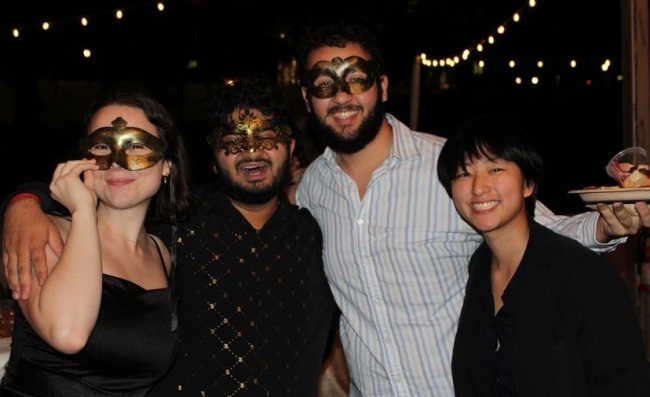 a group of students in dress clothes and masks smile together