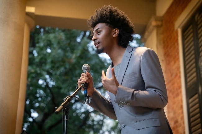 Student speaking at a microphone at the Phi Eu Debate