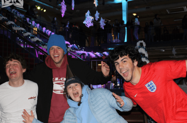 a group of students smiling together in winter gear