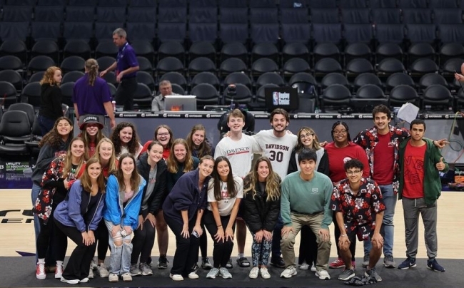 a group of students stand together on an NBA Court