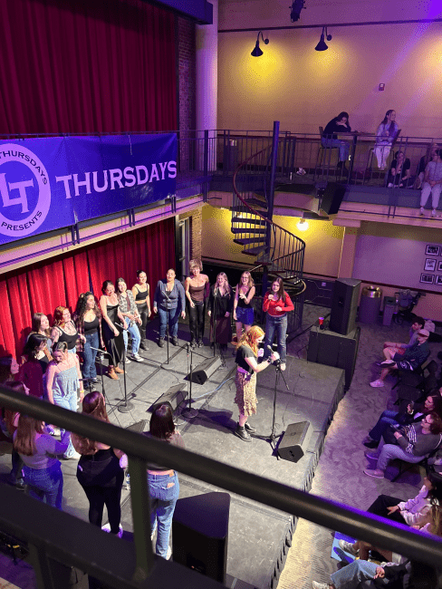 a group of students sing on stage