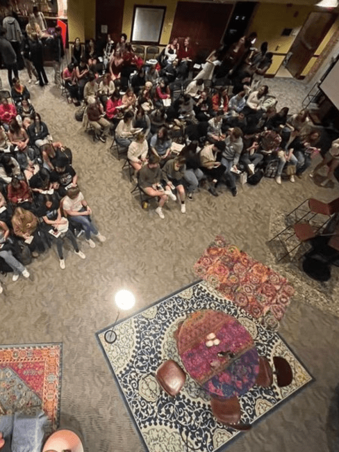 a performance hall filled with students, seen from above