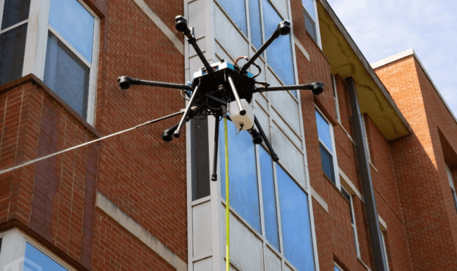 a drone cleans the side of a brick building