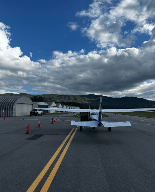 a plane on a tarmac surrounded by warehouses