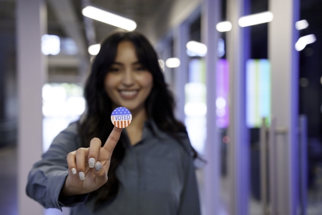 Student holding "I Voted" sticker