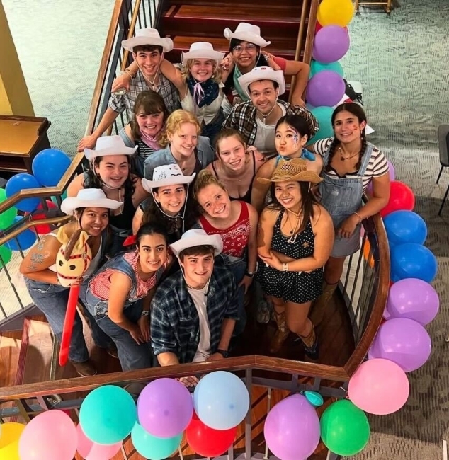 a group of students standing together on a staircase covered in balloons