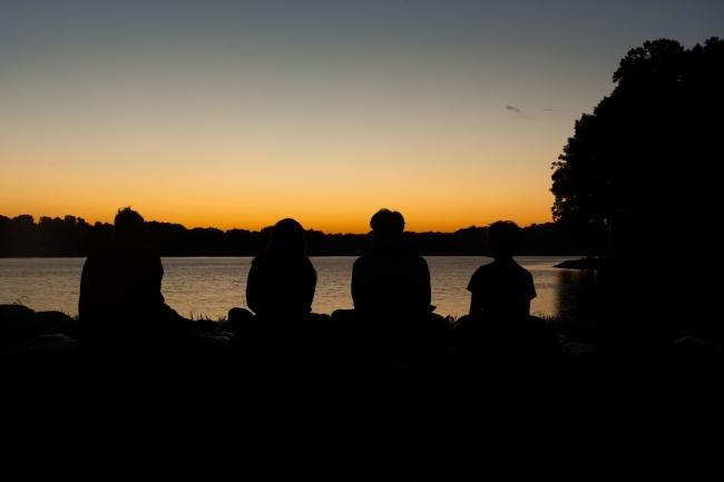 silhouettes of students at lake during davidson outdoors trip