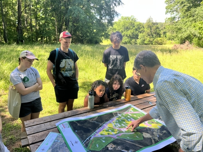 Sustainability Scholars outside looking at map with an expert