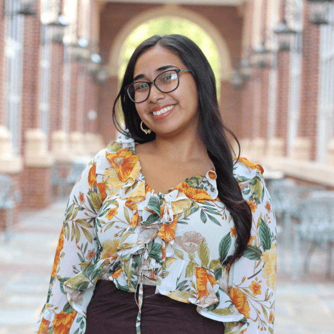 a young woman wearing a floral top and glasses