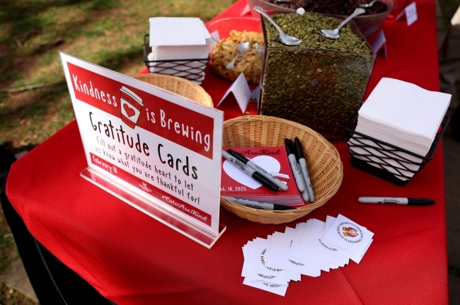 a table covered with art supplies and a sign that reads "Gratitude Cards"