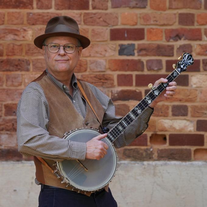 a middle aged white man playing a banjo