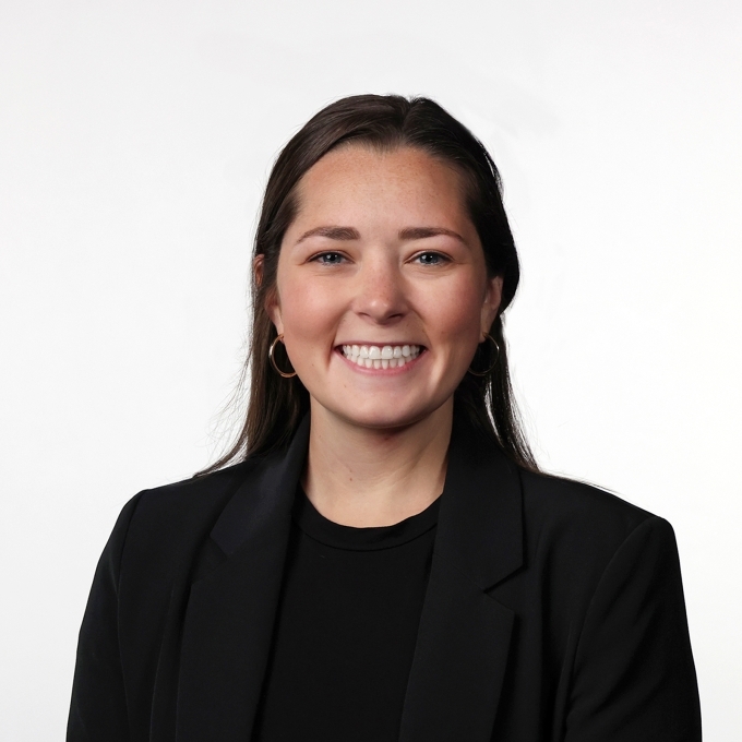 a young white woman wearing a black blazer with brown hair