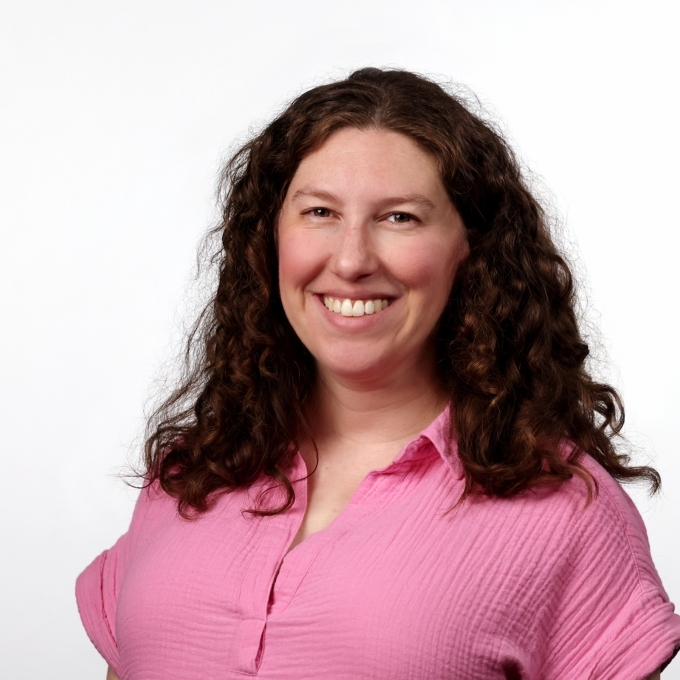 a young white woman with brown hair wearing a pink top