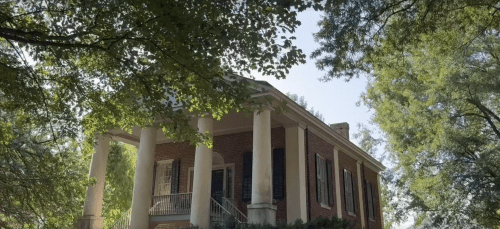 an older brick building with white columns