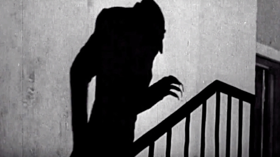 Halloween video screen shot of creepy shadow up the stairs