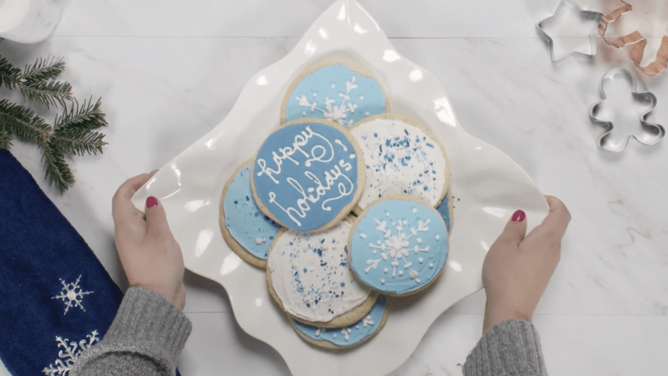 Person placing platter of cookies on a table 