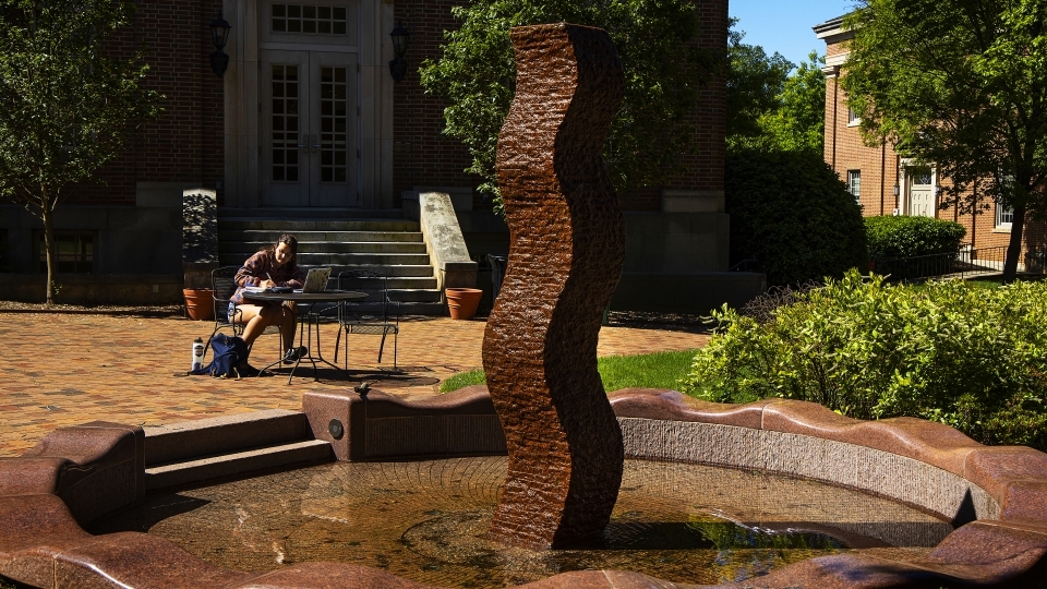 Student studying by art sculpture