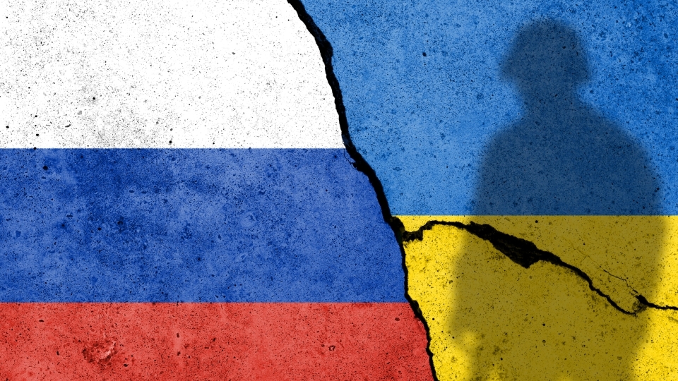 Russian and Ukraine Flags on Cracked pavement