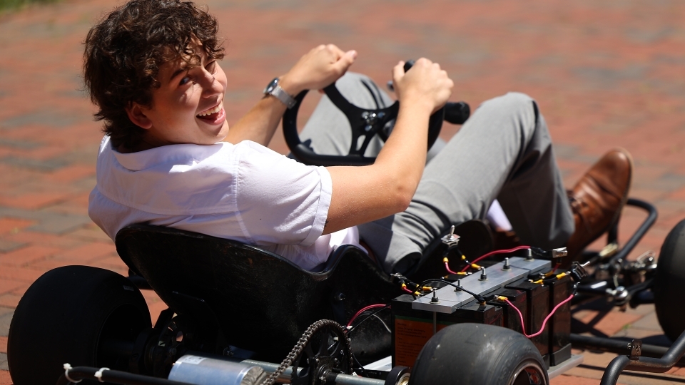 Student smiling and driving gokart