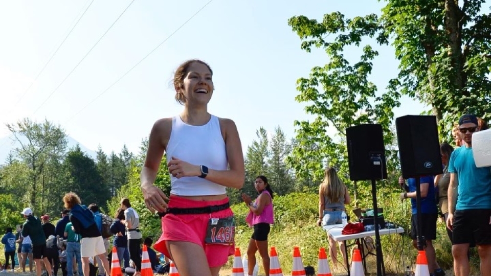 a young woman wears athletics while running a road race