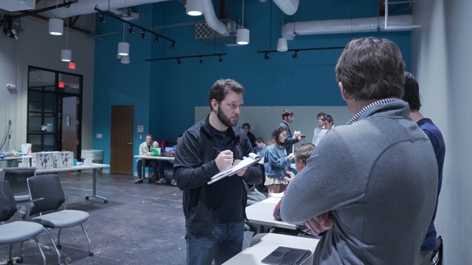 adults and students talk to each other in an innovation center