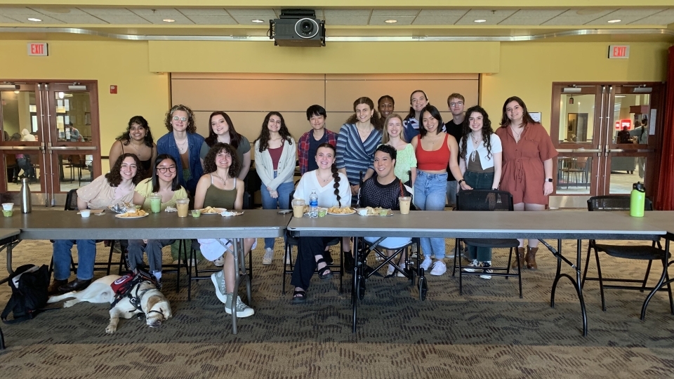 a group of students sit behind a table as part of an event