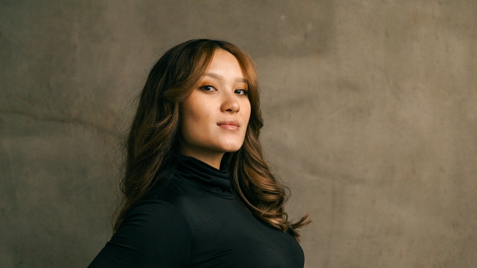 a woman holding her belly in front of a grey background