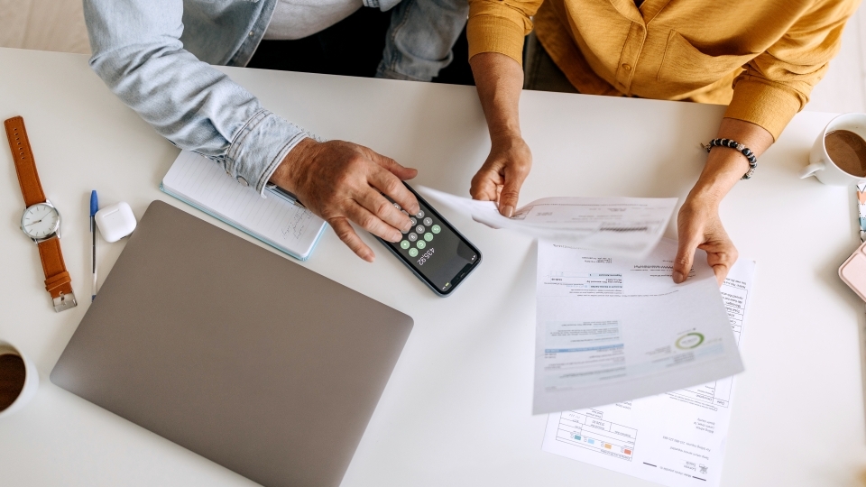 two people sitting at a table with paperwork