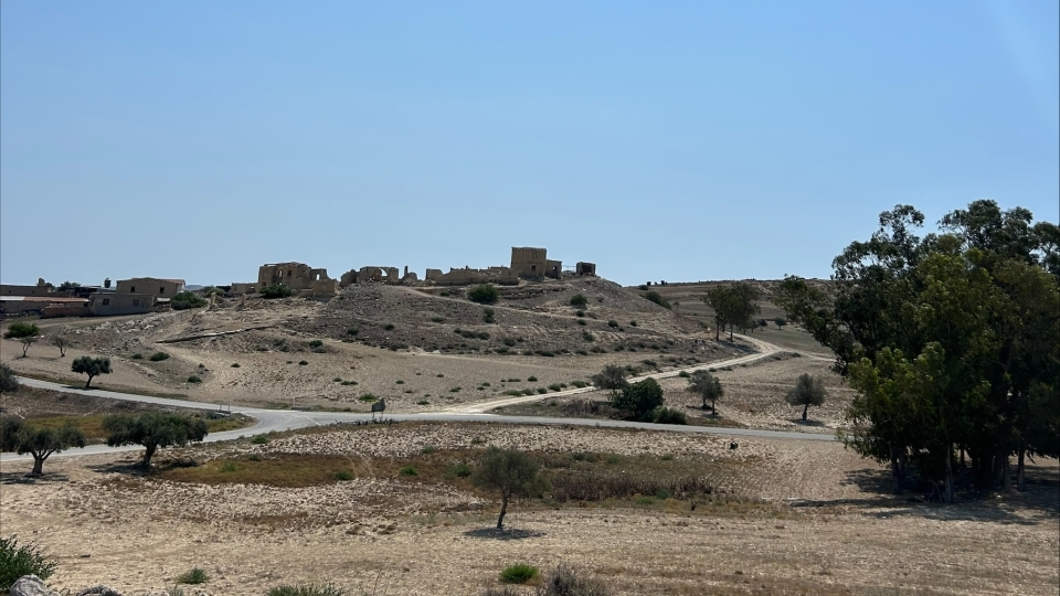 a view of rolling hills with a blue sky in the background